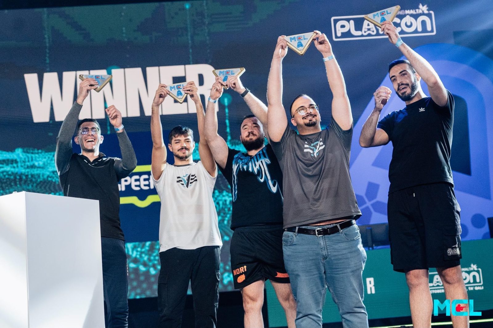 Kurt's team on stage holding winner plaques at an MCL event